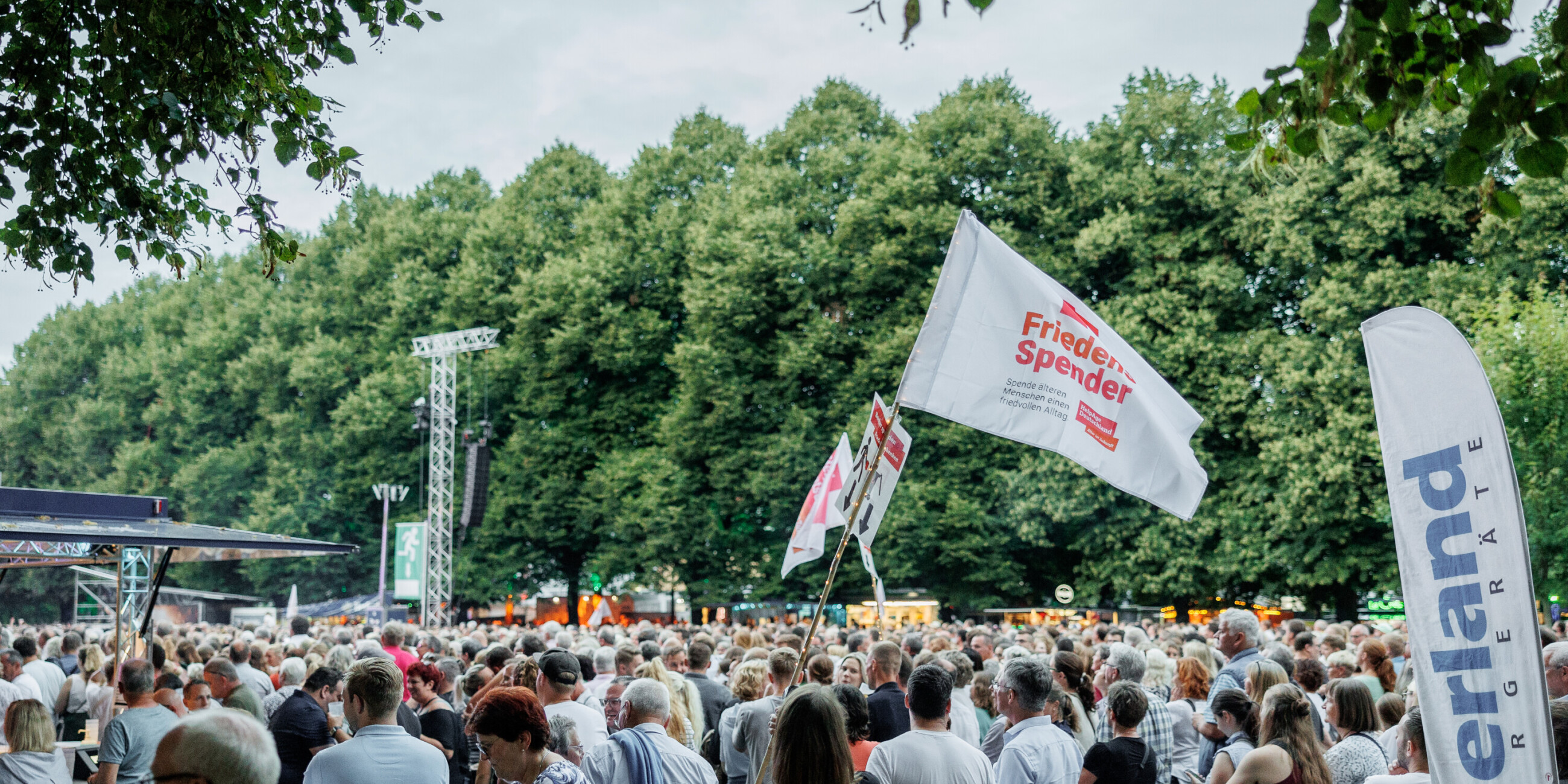 Fahne mit dem Logo vom FriedensSpender Logo in einer Maße von Menschen