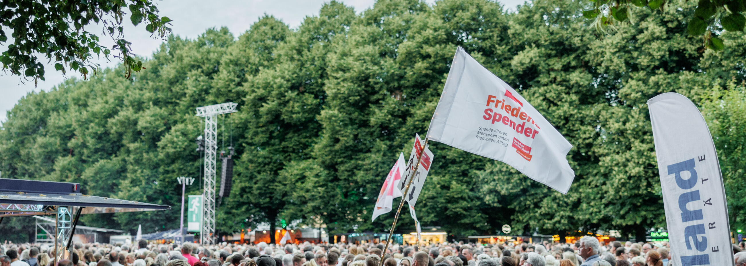 Fahne mit dem Logo vom FriedensSpender Logo in einer Maße von Menschen