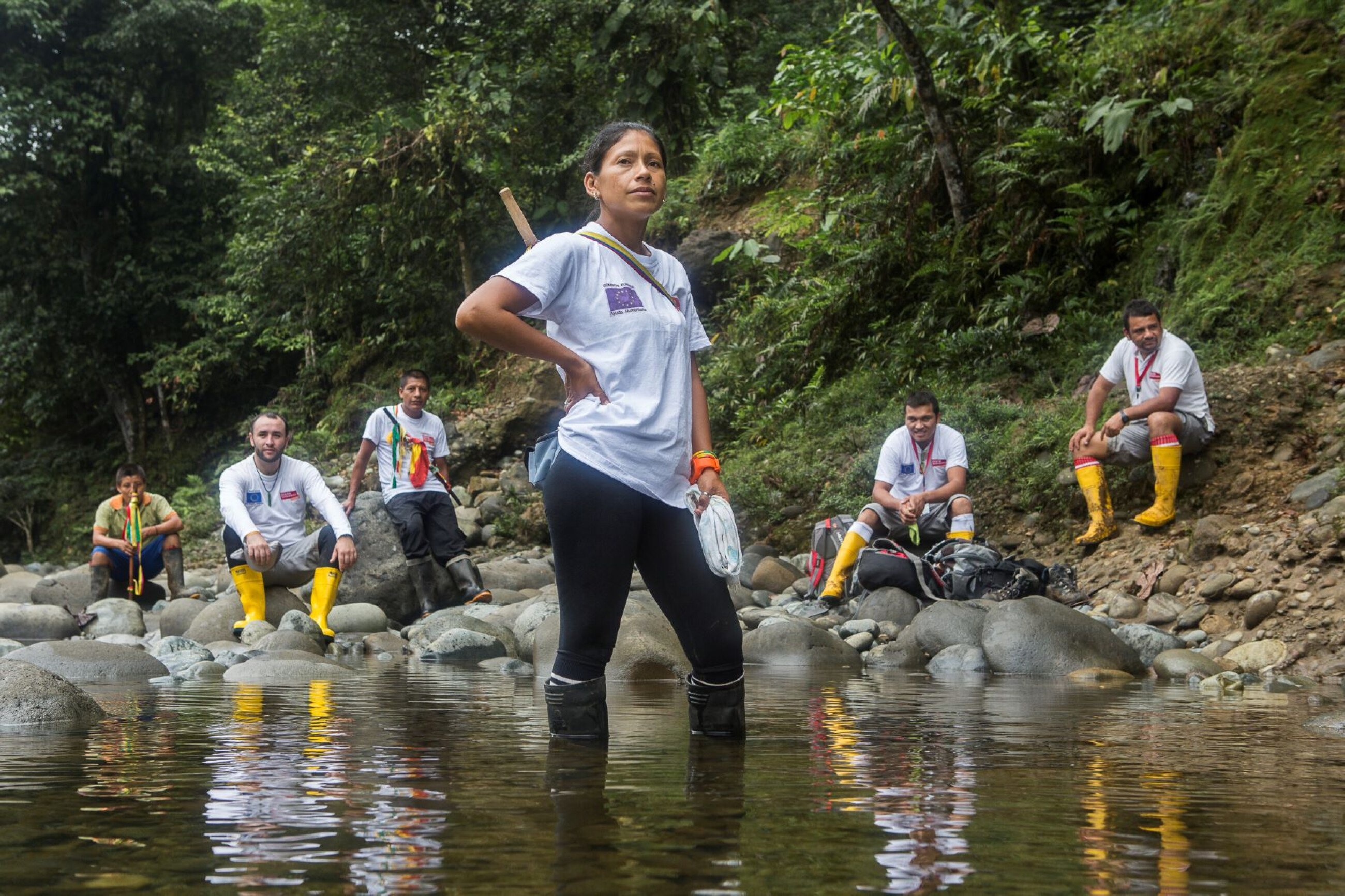 Frau steht im Fluss und im Hintergrund sind weitere Menschen